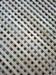 Wooden lattice texture showing an intricate pattern of intersecting slats and open spaces suitable for various design uses