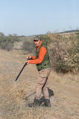 The hunter reloads his gun and prepares to shoot at game