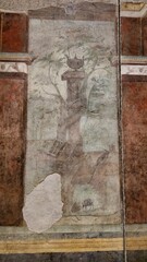 Rome, Italy - 13 January 2025. A vessel-topped pedestal rises among trees with an ox cart below in this partially damaged fresco from the House of Livia.