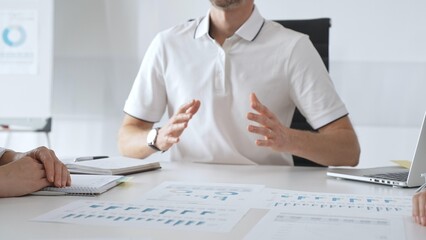 Professional team reviewing financial charts, collaborating intently around conference table in contemporary workspace, sharing insights during strategic planning session