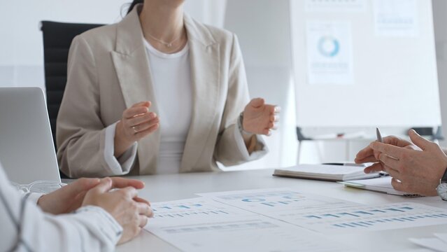Business people team discussing financial data and analyzing charts during a productive meeting in the office, focusing on collaborative teamwork and strategic decision making - Powered by Adobe
