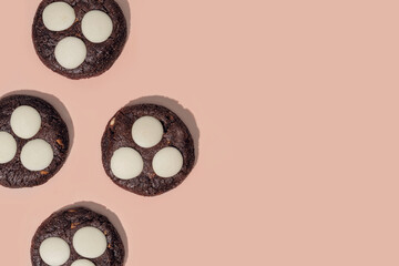 Chocolate cookies with white chocolate chips on a soft pastel background with copy space