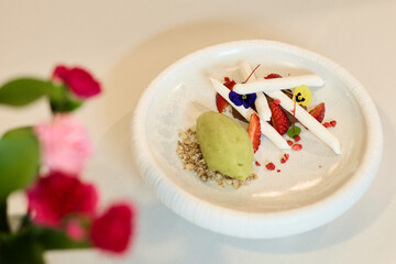 Gourmet dessert with meringue, strawberries, and green sorbet