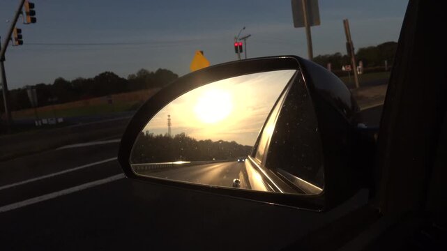Prince Frederick, Maryland USA The view in a rear view side mirror of a car traveling on a highway at sunrise.  