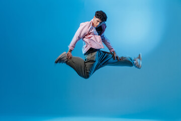 Obraz premium Bboy airborne jump in neon studio hiphop move with copy space