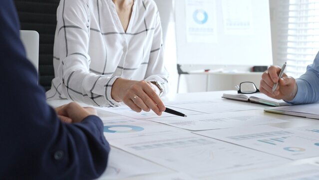 A business meeting with colleagues in a modern office where financial schedules, work planning, and reports are discussed in a team effort - Powered by Adobe