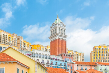 Colorful Mediterranean style buildings with palm trees and tall clock tower in Sunset Town, Phu Quoc island, Vietnam. Italian architecture in Asia. Travel and touristic destination