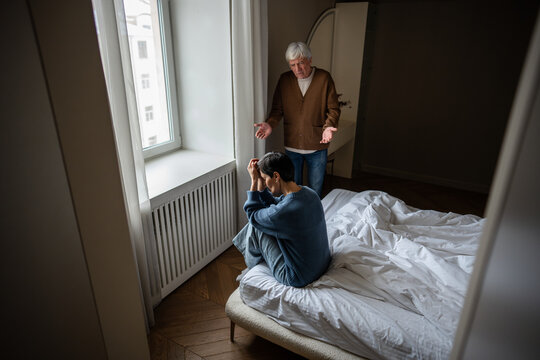 Grieving depressed woman crying in bed man shocked trying to comfort her. Mental health, response under stress, struggle with mood disorder, need for help, husband help in crisis, partner support