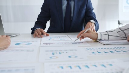 Business professionals discuss financial reports and marketing strategies during a corporate meeting, focusing on marketing, planning, data analysis, and teamwork