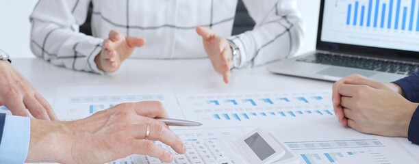 Business people or accouters analyzing financial data using charts, graphs, and reports during an office meeting, collaborating on strategy