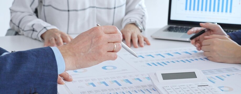 Business professionals analyzing financial data and market trends during a corporate meeting, collaborating on reports and planning strategic growth in the office