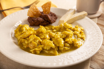 Scrambled eggs in green sauce. A typical Mexican breakfast of scrambled eggs bathed in spicy green sauce, usually accompanied by beans and pot coffee.