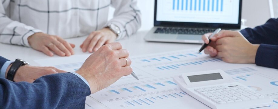 Business professionals analyzing financial data and market trends during a corporate meeting, collaborating on reports and planning strategic growth in the office - Powered by Adobe