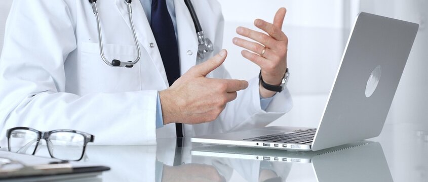 Doctor in white coat and stethoscope providing virtual medical consultation, discussing health issues with a patient online. Medicine, healthcare and science concept