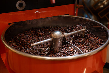Roasting cocoa beans in industrial roaster for rich chocolate flavor on factory