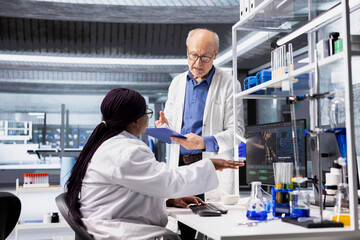 Diverse experts working on biotechnology research with DNA analysis on computer, collaboration to examine genetics, molecular science and clinical diagnostics in modern laboratory.