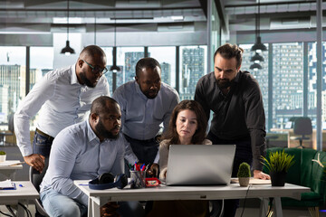 Business colleagues using computers to analyze insights and performance metrics, making projections...