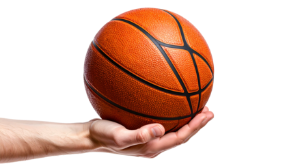 A hand cradles a basketball against a stark black background, showcasing the sphere's texture