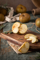 A rustic still life with sliced russet apples sprinkled with cinnamon on a wooden cutting board, evoking a cozy, autumnal mood