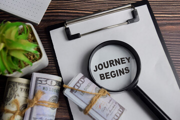 Concept of journey begins write on clipboard isolated on Wooden Table.
