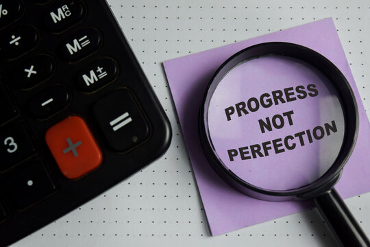 Concept of progress not perfection write on sticky notes isolated on Wooden Table.