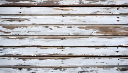 Obraz premium Close-up background of an old weathered wooden wall with peeling white paint revealing the texture underneath.