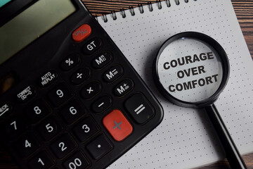 Concept of courage over comfort write on book with keywords isolated on Wooden Table.