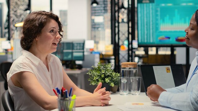 Recruiter from the HR department evaluating a confident woman applicant during professional conversation about employment and onboarding in growing business organization. Head hunting. Camera B.
