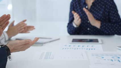 Business team applauding after successful presentation during a meeting in the office, celebrating achievement and good teamwork with positive attitude