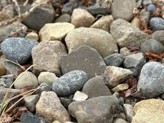 Macro view of gravel and rock fragments along a dirt pathway, showing the natural pattern and color variation of outdoor road surfaces.