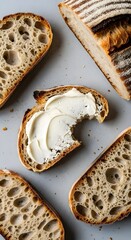 Slices of sourdough bread, one with cream cheese and a bite taken out of it.