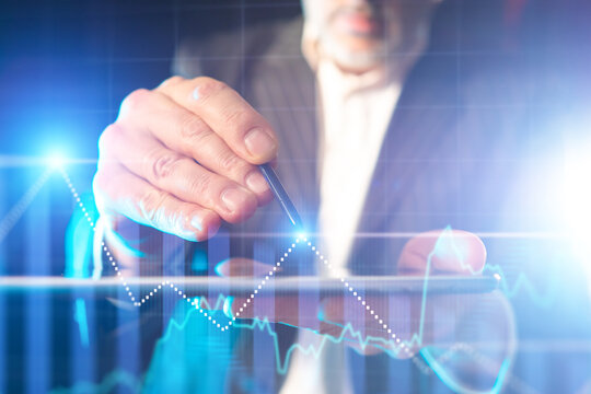 Financial analyst uses digital tablet to track stock market charts, analyzing investment trends, business growth, and economic data.