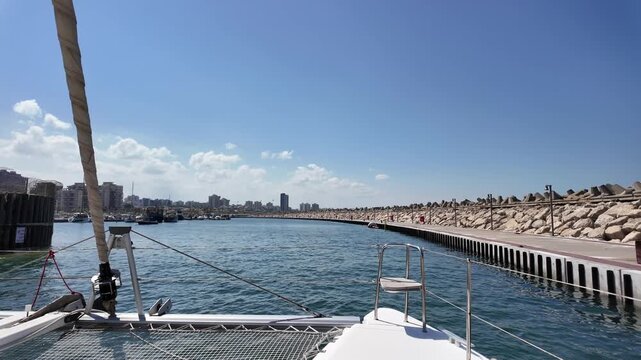 Luxury yacht anchored in a peaceful marina near Ashdod Port, Israel. Calm sea, blue sky, and modern harbor scenery along the Mediterranean coast.