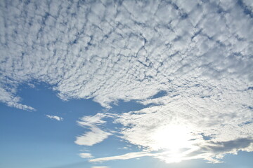 Obraz premium The sun peeks out from behind the delicate cirrus clouds