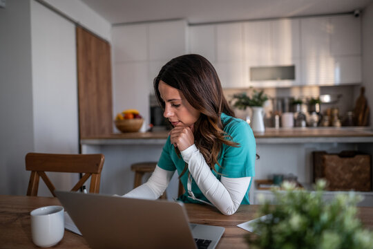 Female healthcare professional working from home on laptop