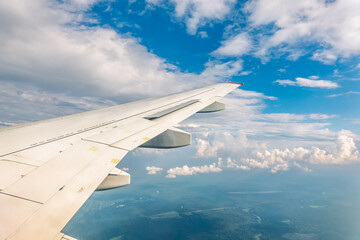 Obraz premium View from the airplane window at a beautiful cloudy sky and the airplane wing