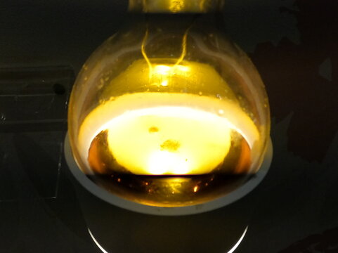 PROBETA DE BOLA LUMINOSA CON LIQUIDO ABARILLO ALUMBRANDO LA OSCURIDAD