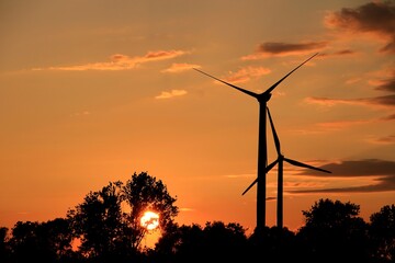 Wind turbines at sunset with orange sky
