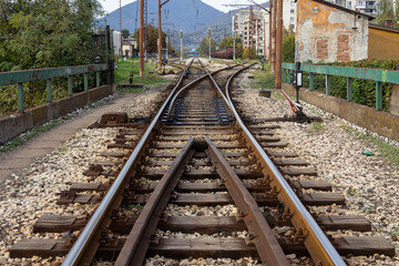 Obraz premium Railway tracks stretching into the distance through an urban area, representing travel, transportation, and perspective in a modern city environment.