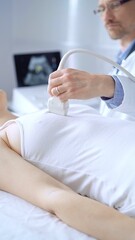 Doctor man using ultrasound equipment on the breast of a female patient. Mammary gland health....