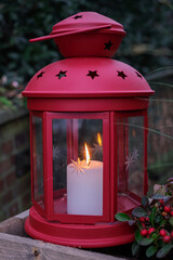 Rotes Windlicht mit brennender Kerze