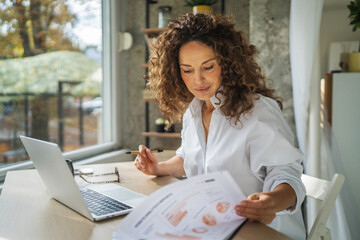 Woman analyzing document content working from home office