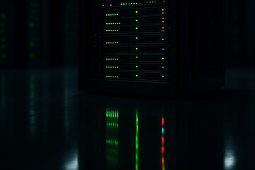 Digital Fortress: Dark Server Rack with Status Lights Reflecting on a Data Center Floor