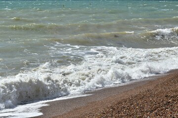 Sea waves on the sandy beach, English Channel, Brighton, UK