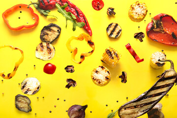 Different tasty grilled vegetables flying on yellow background