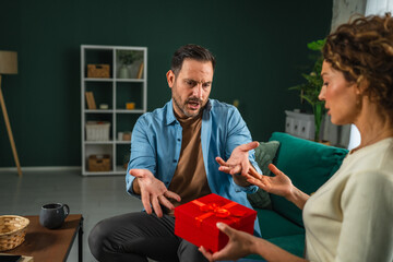 Man rejecting gift from woman during argument