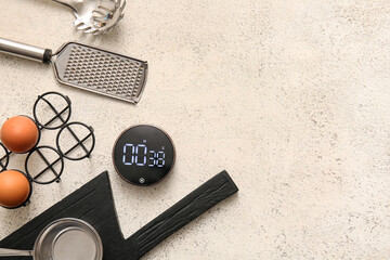 Naklejka premium Modern kitchen timer and utensils on light grunge background