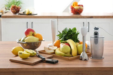 Modern blender and different fresh fruits on table in kitchen