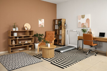 Interior of living room with treadmill, table and workplace