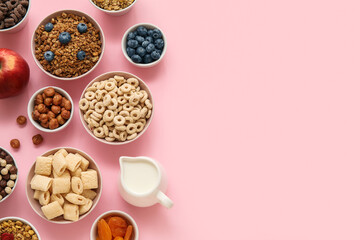 Bowls with different cereals and ingredients on pink background